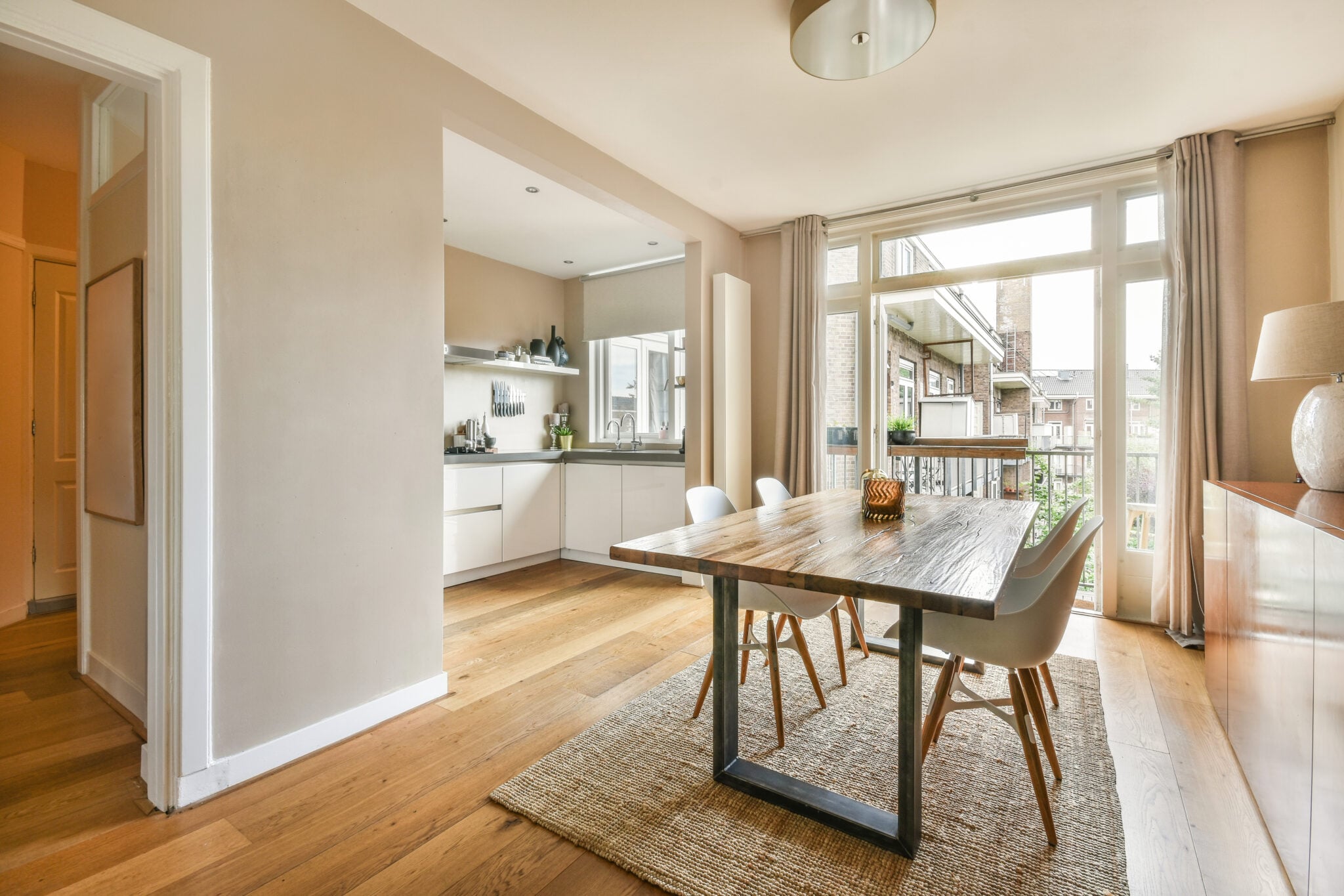 Home interior design of modern loft apartment with open kitchen in minimalist style and spacious dining zone with table and chairs